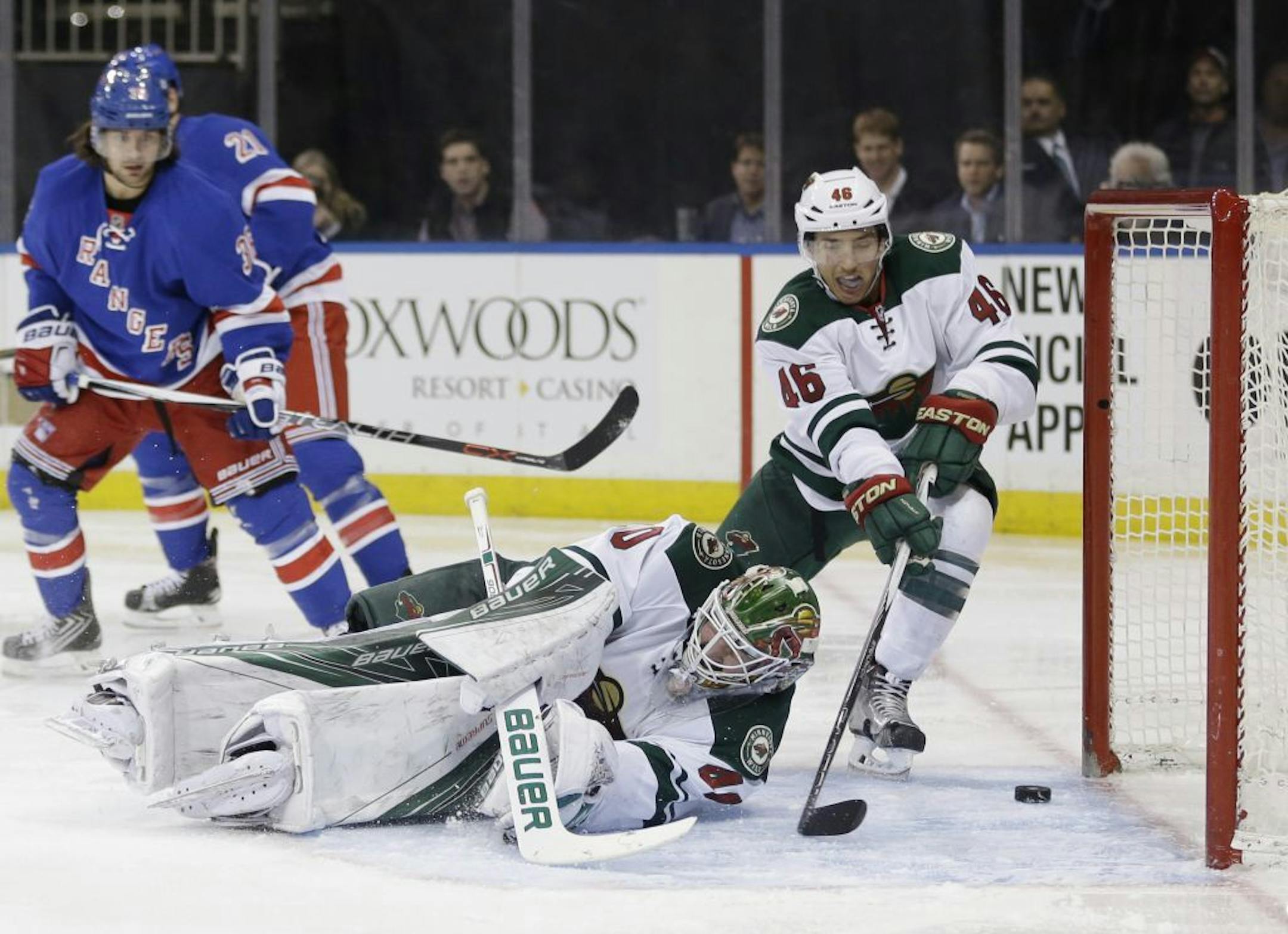 A shot by New York Rangers Ryan McDonagh moves past Minnesota Wild defenseman Jared Spurgeon (46), right, and goalie Devan Dubnyk (40) into the goal during the second period of the NHL hockey game, Thursday, Feb. 4, 2016, in New York.