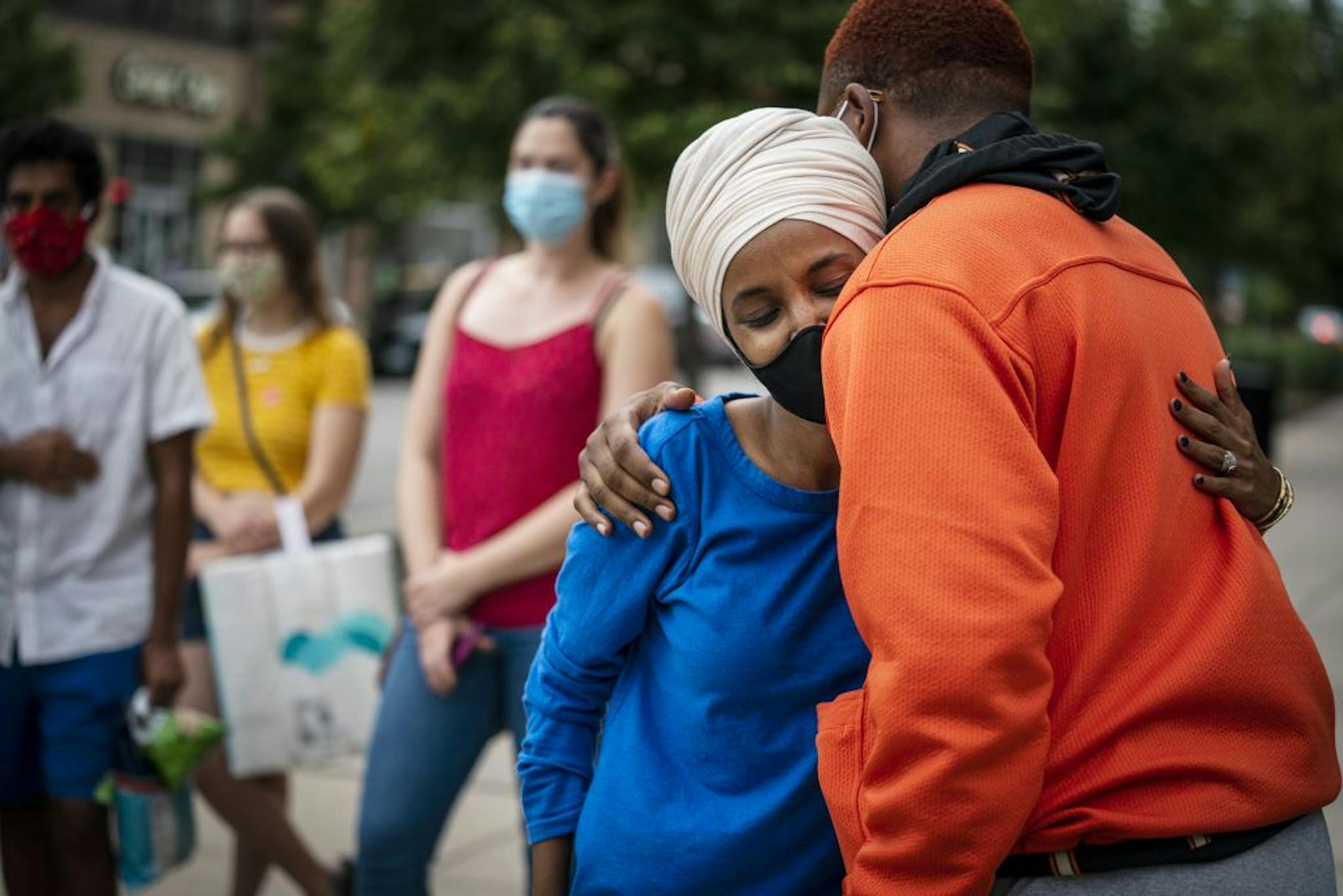 Rep. Ilhan Omar, second from right, D-Minn., greets a young voter outside the Dinkytown Target near the University of Minnesota campus in Minneapolis on Tuesday, Aug. 11, 2020.