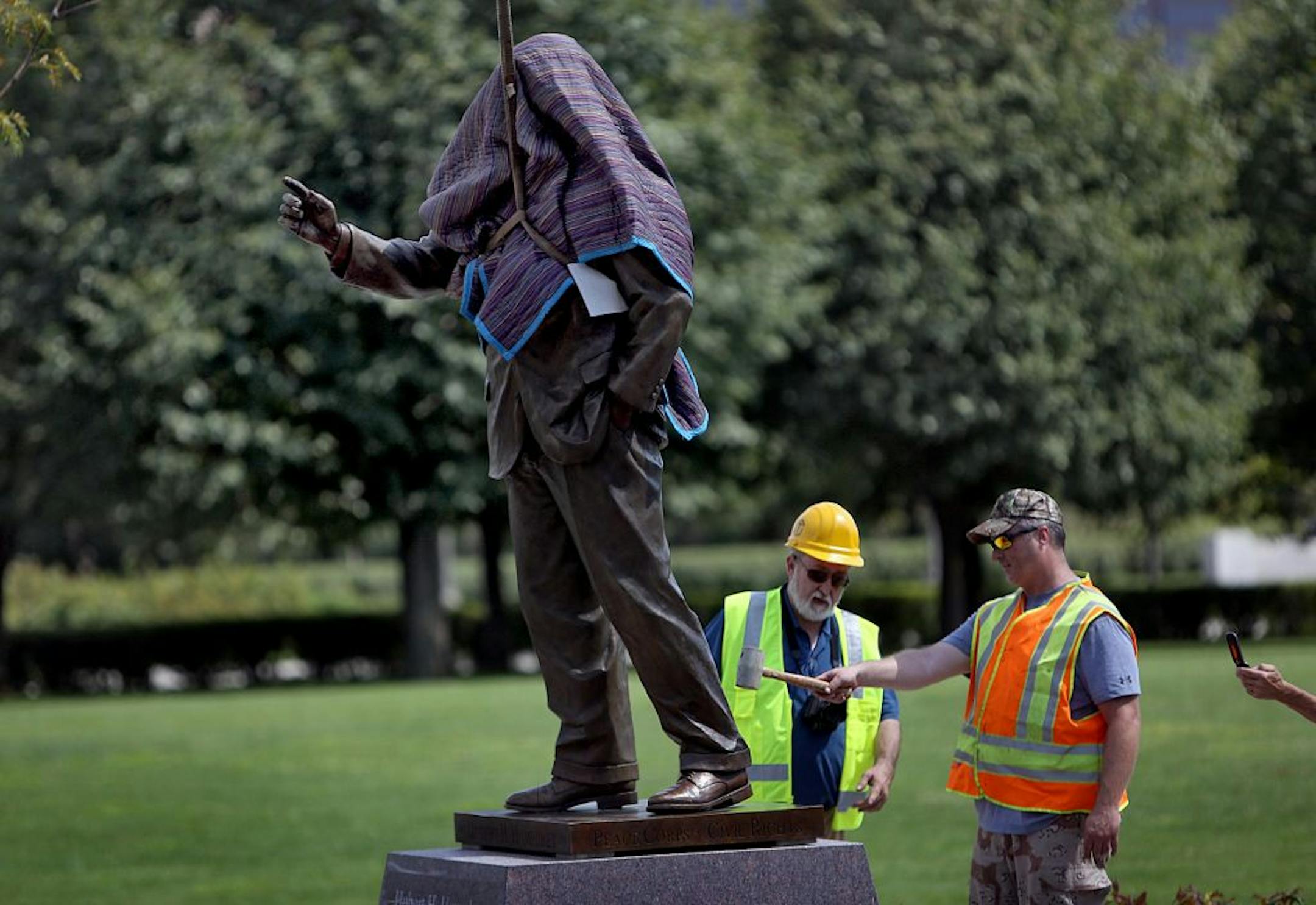 Workers installed a new, 750 lbs, bronze statue of Hubert H. Humphrey at the Humphrey Memorial site at the State Capitol Mall, in preparation for a dedication ceremony this weekend. The statue is located at the intersection of John Ireland and Rev. Dr. Martin Luther King Jr. Blvds. Gary Pavlicek is at left, while worker with hammer asked not to be identified.