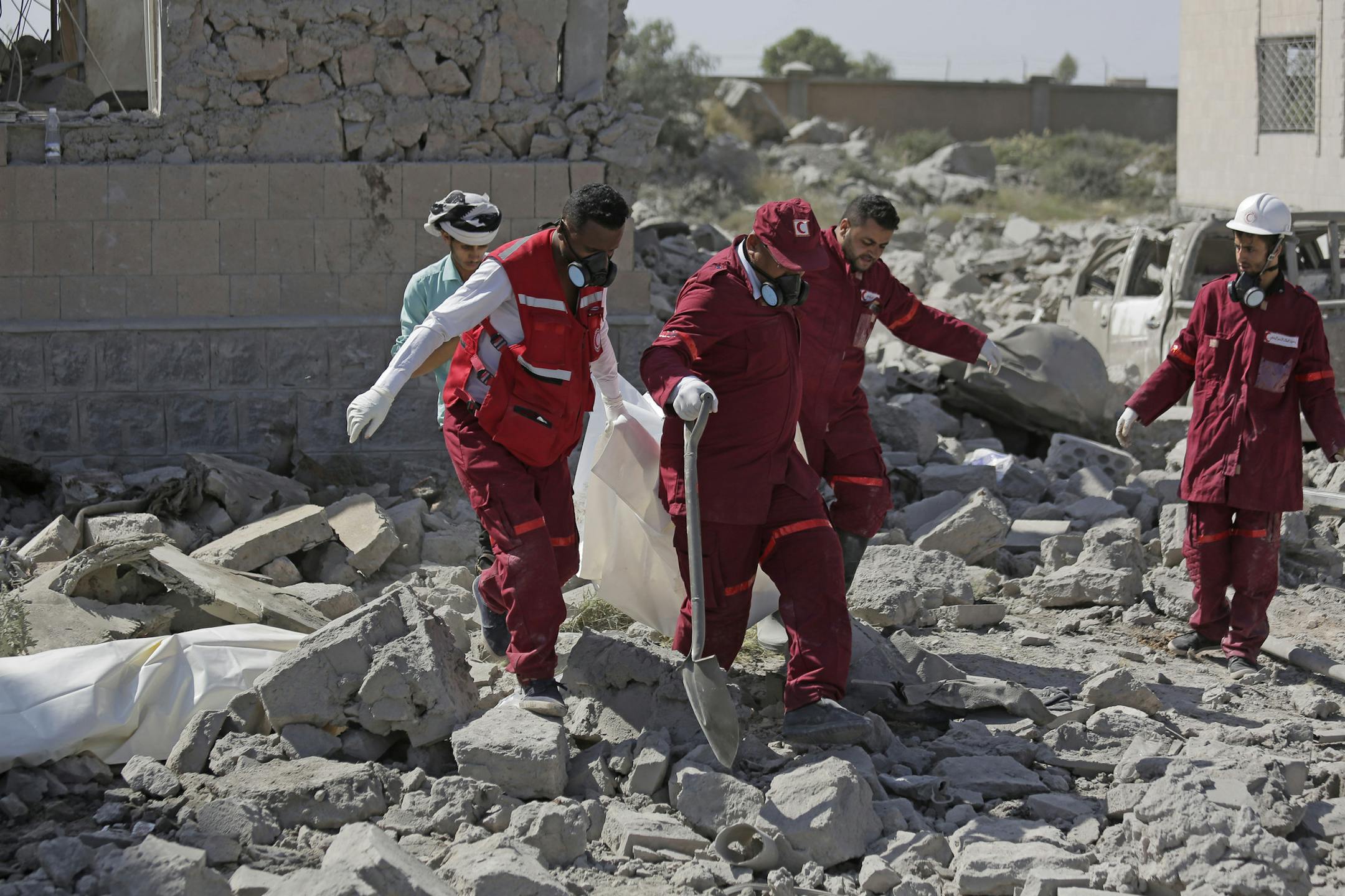 Rescue workers carry a body from under the rubble of a Houthi detention center destroyed by Saudi-led airstrikes, that killed at least 60 people and wounding several dozen according to officials and the rebels' health ministry, in Dhamar province, southwestern Yemen, Sunday, Sept. 1, 2019. The officials said the airstrikes took place Sunday and targeted a college in the city of Dhamar, which the Houthi rebels use as a detention center. The Saudi-led coalition said it had hit a Houthi military fa