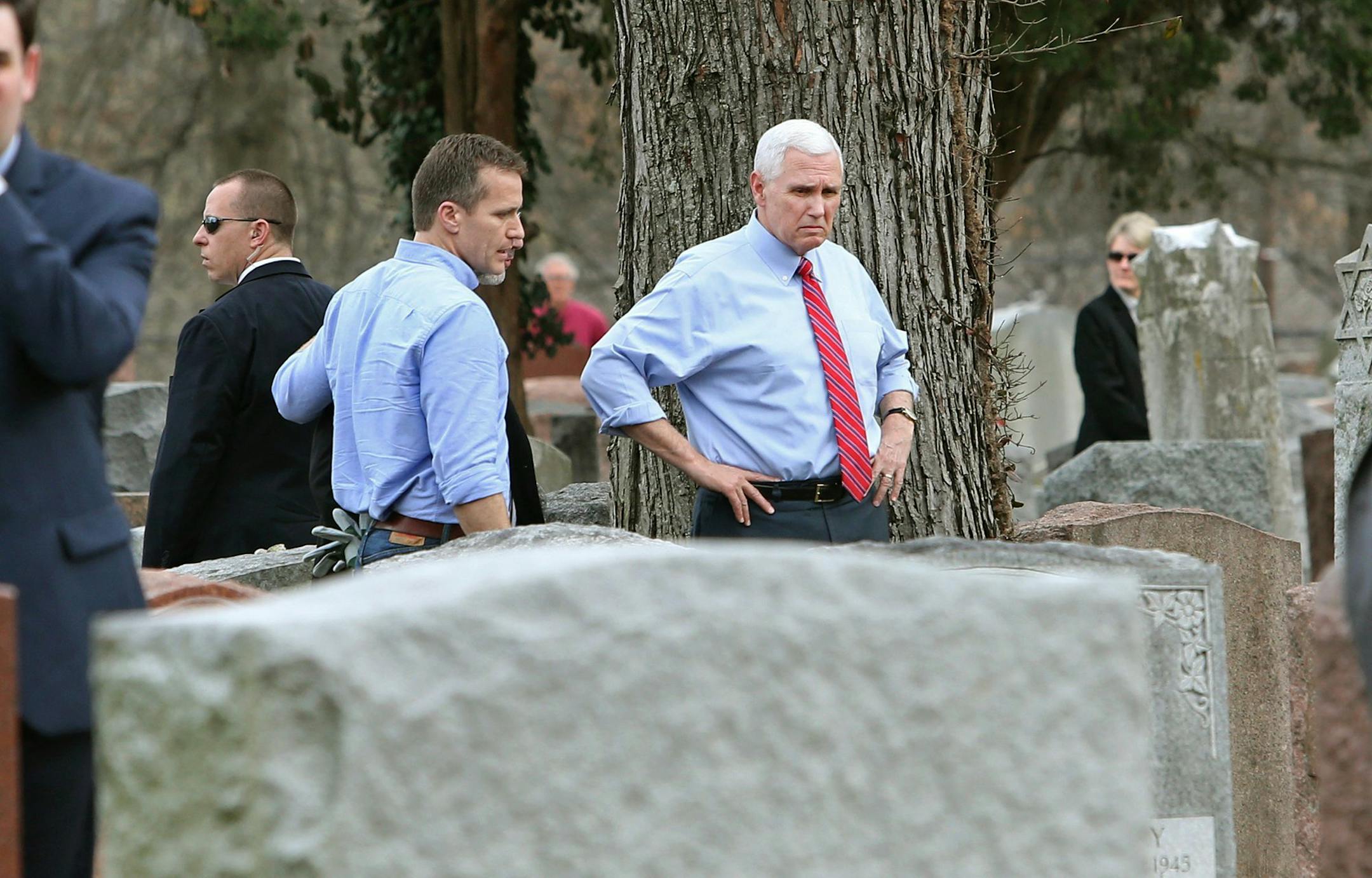 Missouri Gov. Eric Greitens and Vice President Mike Pence view some of the damage done at the Chesed Shel Emeth Cemetery in University City, Mo., on Wednesday, Feb. 22, 2017. Over 150 headstones had been overturned by vandals. (J.B. Forbes /St. Louis Post-Dispatch via AP)