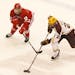 Wisconsin's Grant Besse (12) and Minnesota's Darian Romanko (26) chase after the puck during the first period