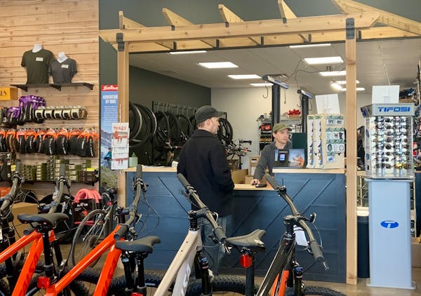 John Sheehan, owner of ROAM Bike Shop in White Bear Lake, right, said questions about the electric bike tax rebate are No. 1 these days.