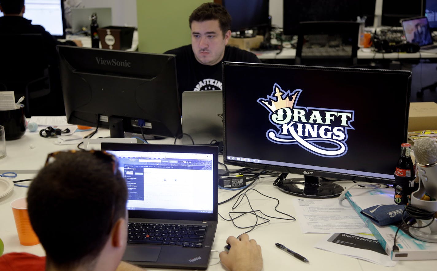 In this Wednesday, Sept. 9, 2015, photo, Len Don Diego, marketing manager for content at DraftKings, a daily fantasy sports company, works at his station at the company's offices in Boston.