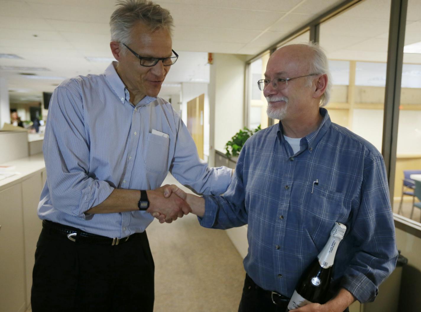 Steve Sack, right, (here congratulated by Dave Hage) won a Pulitzer Prize for the editorial cartooning award.