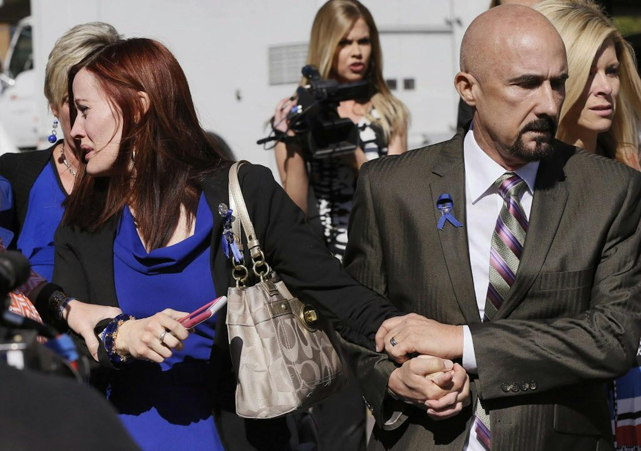 Tanisha Sorenson, sister of murder victim Travis Alexander, cries as she leaves the court house with family and friends, Thursday, March 5, 2015, in Phoenix.