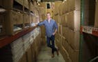 Tim Murphy, president of Softies, posed for a photo in the stacked boxes of their Edina warehouse, boxes that will all be sent in the next week after 