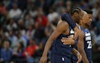 Wolves forward Taj Gibson wrapped his arms around teammate Andrew Wiggins after Wiggins scored a basket against the Hornets in the second half Sunday.