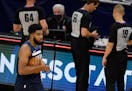 In this file photo, Karl-Anthony Towns (32) of the Minnesota Timberwolves hugs a basketball as he walks off the court after the season-opening game ag