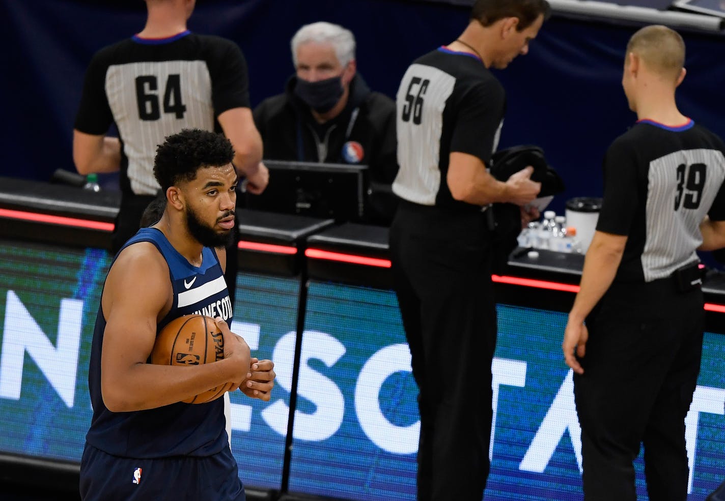 In this file photo, Karl-Anthony Towns (32) of the Minnesota Timberwolves hugs a basketball as he walks off the court after the season-opening game against the Detroit Pistons at Target Center on December 23, 2020 in Minneapolis, Minnesota. (Hannah Foslien/Getty Images/TNS) ORG XMIT: 6074279W