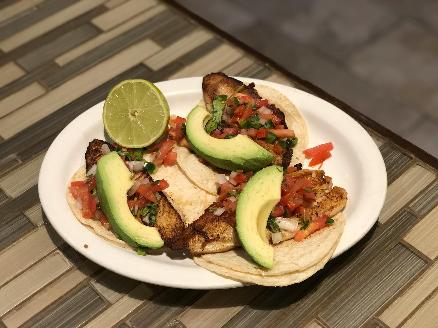 Three fish tacos from El Parian Mexican Restaurant are topped with pico, avocados and cilantro.