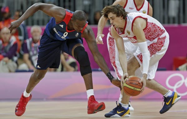 Britain's Luol Deng, left, reaches down as he tries to steal from Russia's Alexey Shved