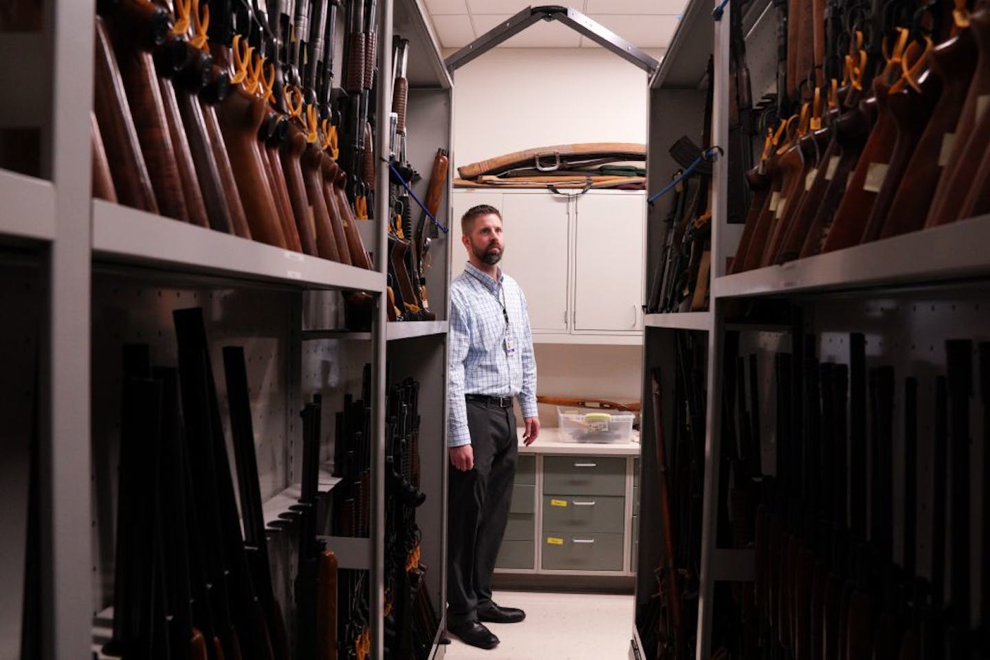 BCA forensic science supervisor Steve Swenson looked over the guns of every make, model, and caliber that lined the walls at the BCA's firearm reference library Wednesday.