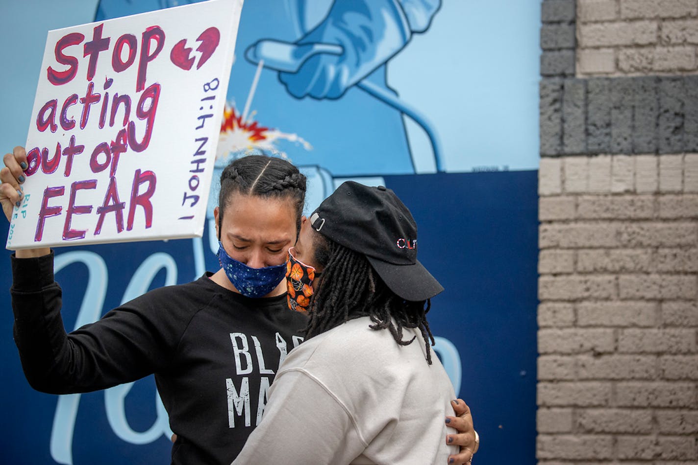 Asha Knight, left, was comforted Tuesday by Dilonna Johnson near the site where a man died after a confrontation Monday evening with Minneapolis police.