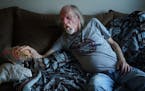Jerry Larson waits for his granddaughter Mia,9 to come home from school as he rests on the couch with a chihuahua he calls Taco. He wished he could go