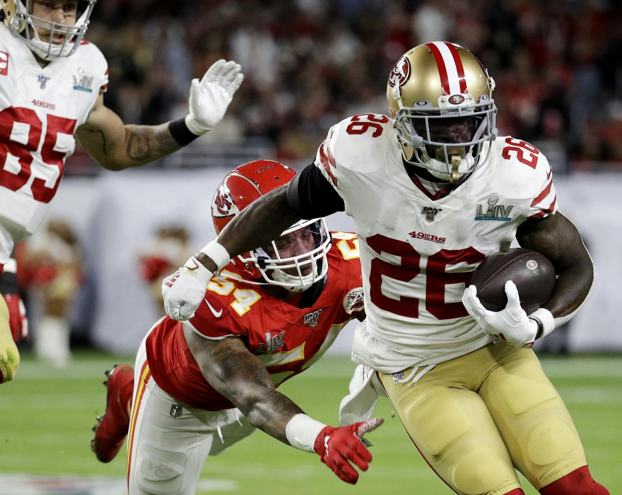 San Francisco 49ers' Tevin Coleman (26) runs against Kansas City Chiefs' Damien Wilson (54) during the first half of the NFL Super Bowl 54 football game Sunday, Feb. 2, 2020, in Miami Gardens, Fla. (AP Photo/Patrick Semansky)
