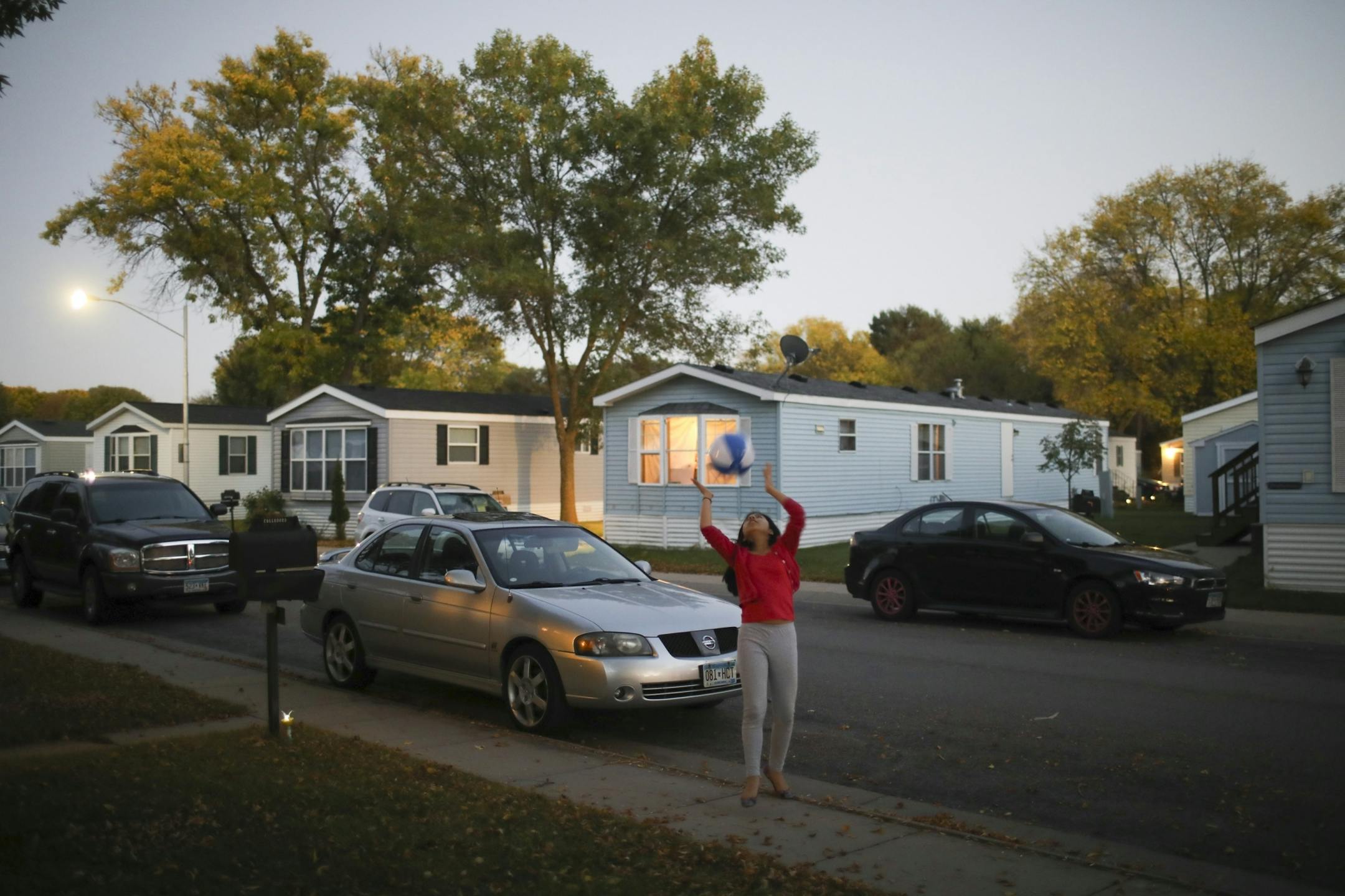 Melina Alvarez, 12, played with a ball across the street from her new home in the Lakeside Homes mobile home park in New Brighton. Her family and several others from Lowry Grove have relocated to Lakeside Homes.