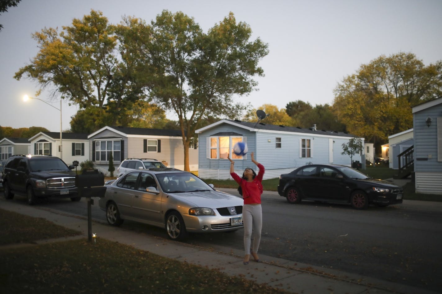 Melina Alvarez, 12, played with a ball across the street from her new home in the Lakeside Homes mobile home park in New Brighton. Her family and several others from Lowry Grove have relocated to Lakeside Homes.