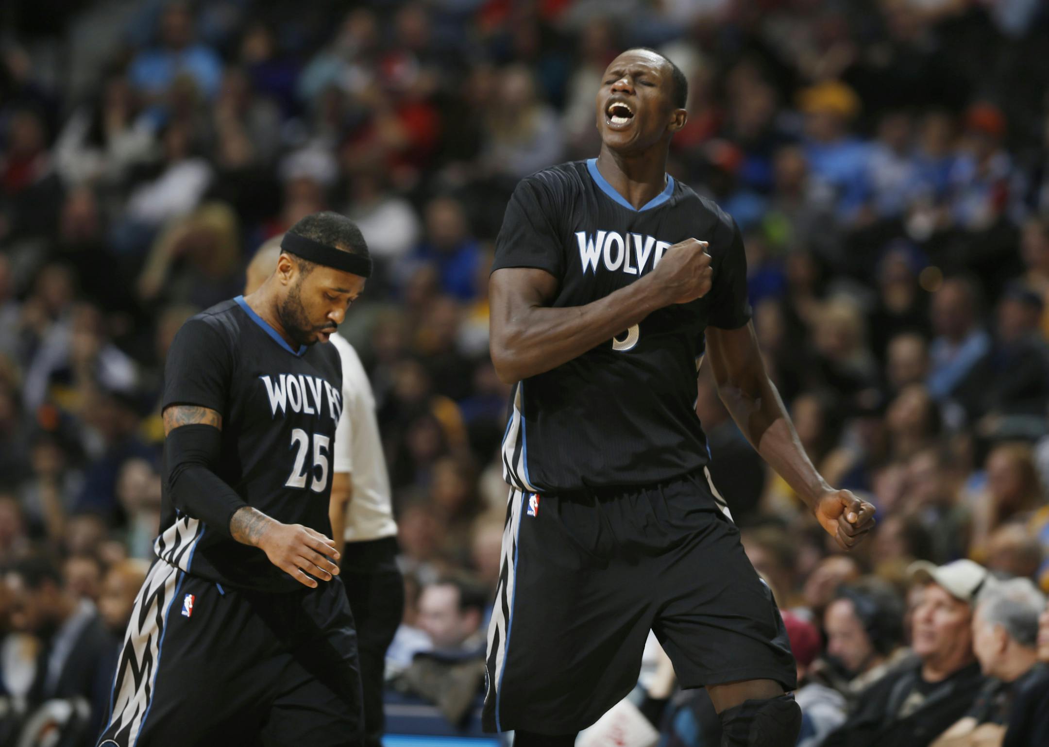 Minnesota Timberwolves center Gorgui Dieng, right, reacts after hitting key baskets on back-to-back possessions to give the Timberwolves 6-point lead over the Denver Nuggets late in the fourth quarter of an NBA basketball game Saturday, Jan. 17, 2015, in Denver. Timberwolves guard Mo Williams, left, follows Dieng to the bench during the time out called by the Nuggets following Dieng's shot. The Timberwolves won 113-105. (AP Photo/David Zalubowski)