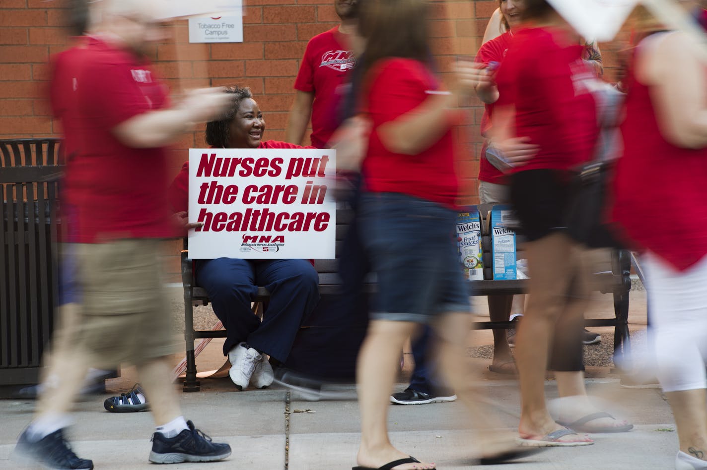 In June, Queen Obasi held up a sign and offered snacks to pickets as they passed by in front of United Hospital in St. Paul.