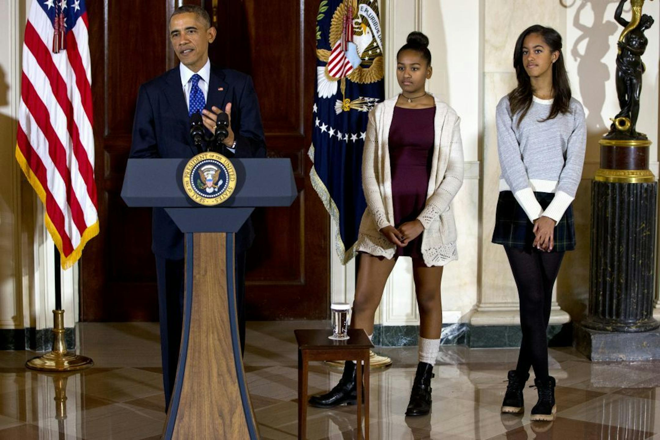 President Barack Obama, joined by his daughters Malia, right, and Sasha, center, speaks at the White House, in Washington, Wednesday, Nov. 26, 2014, during the presidential turkey pardon ceremony, an annual Thanksgiving tradition.