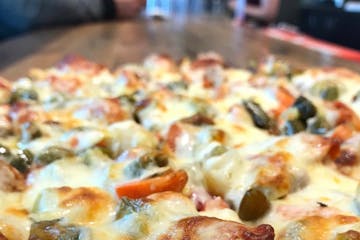 Minnesota-style — according to Red's Savoy — is a thin-crust, square-cut pizza with loads of cheese and toppings and a signature spicy "passive ag