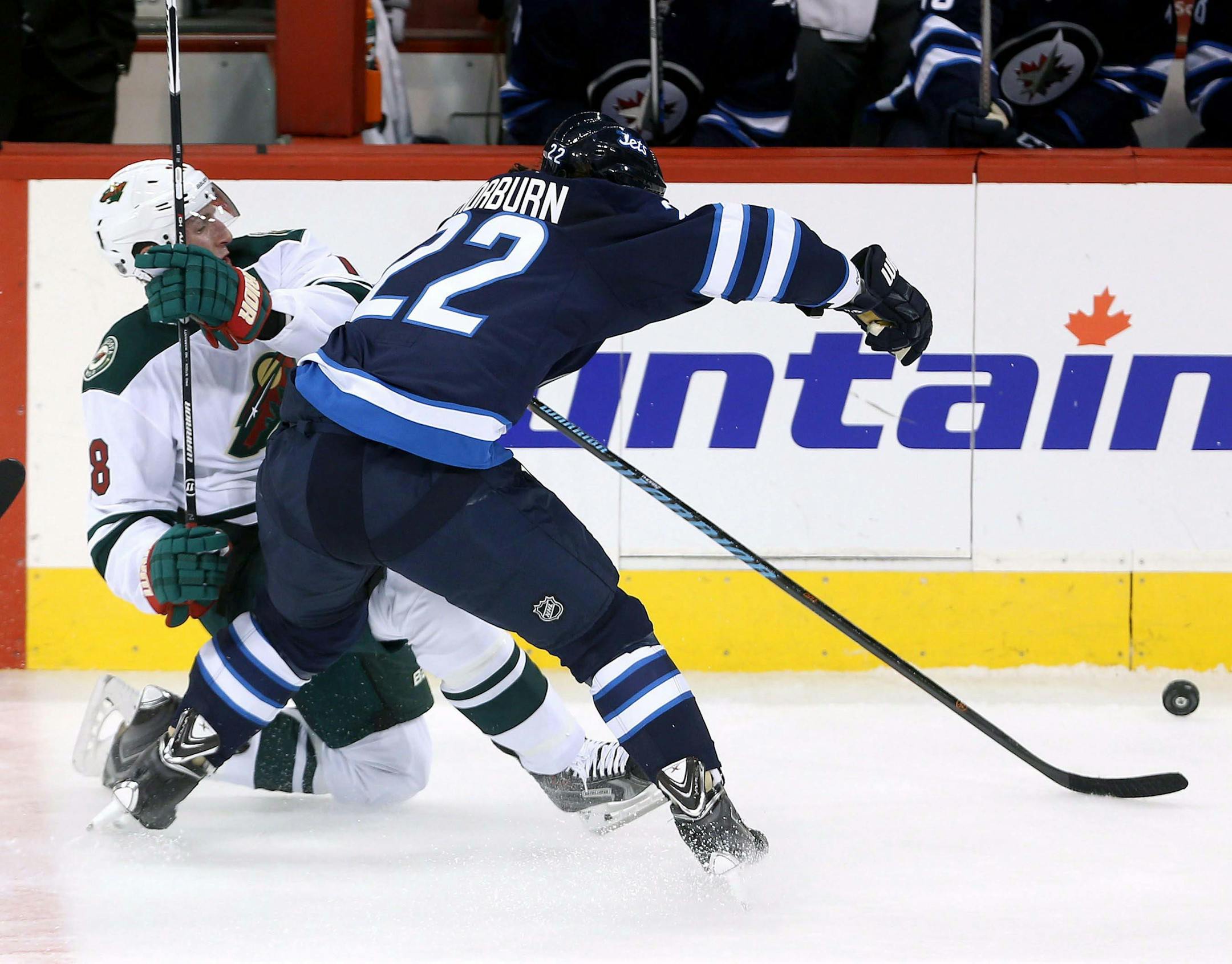 Winnipeg Jets' Chris Thorburn, right, hits Minnesota Wild's Ryan Carter during the first period of an NHL preseason hockey game Tuesday, Sept. 22, 2015, in Winnipeg, Manitoba.
