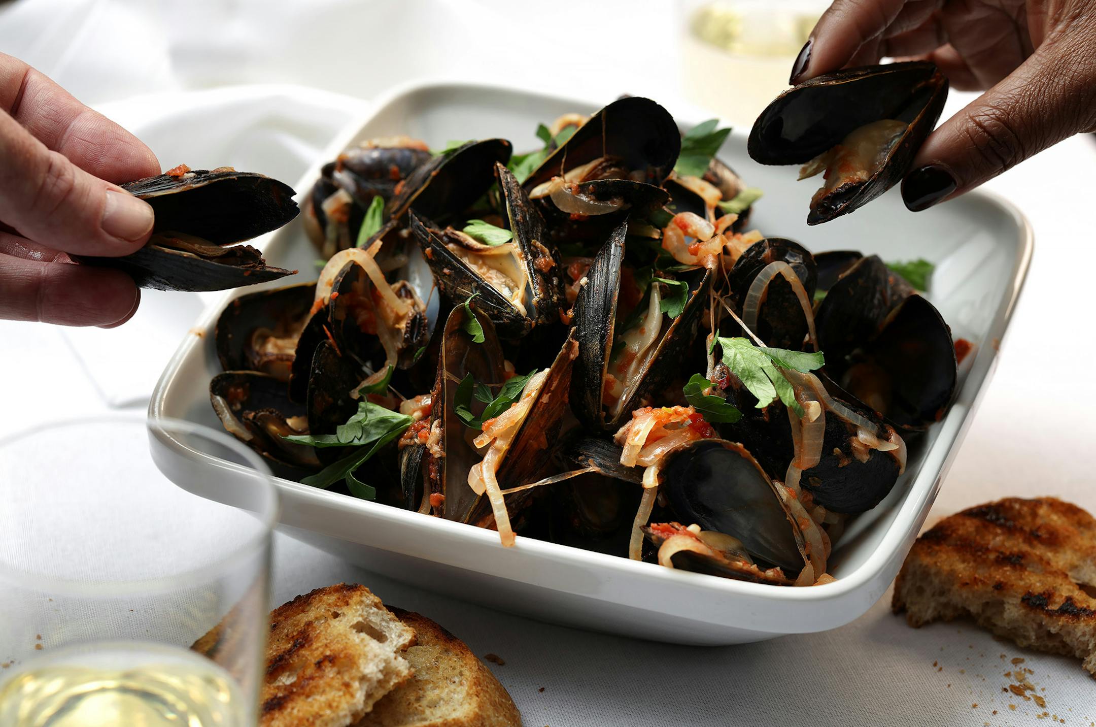 Mussels can be cooked myriad ways; this version keeps it simple with tomatoes, white wine, garlic and red pepper flakes, for a little heat. (E. Jason Wambsgans/Chicago Tribune/TNS) ORG XMIT: 1265985