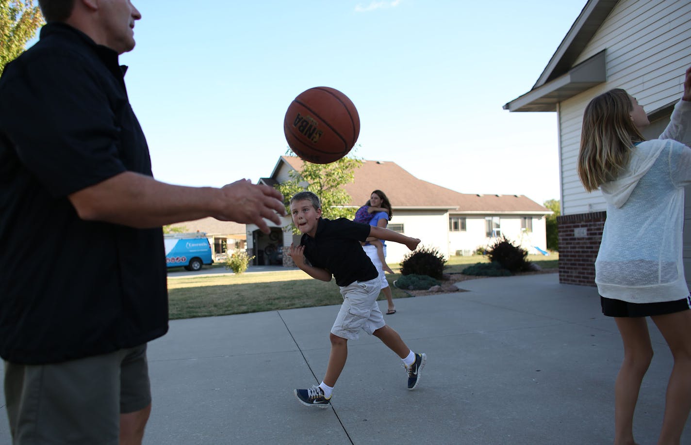 Todd Hoffner got a pass from his middle child Brady, 10, as they played a basketball game in their driveway. ] (KYNDELL HARKNESS/STAR TRIBUNE) kyndell.harkness@startribune.com At the home of Todd Hoffner, who lost his job at Minnesota State Mankato as football coach when he was accused of taking inappropriate pictures of his children on a University-issued cell phone, but later cleared an got his job back in Mankato Min. Tuesday, August, 12, 2014.