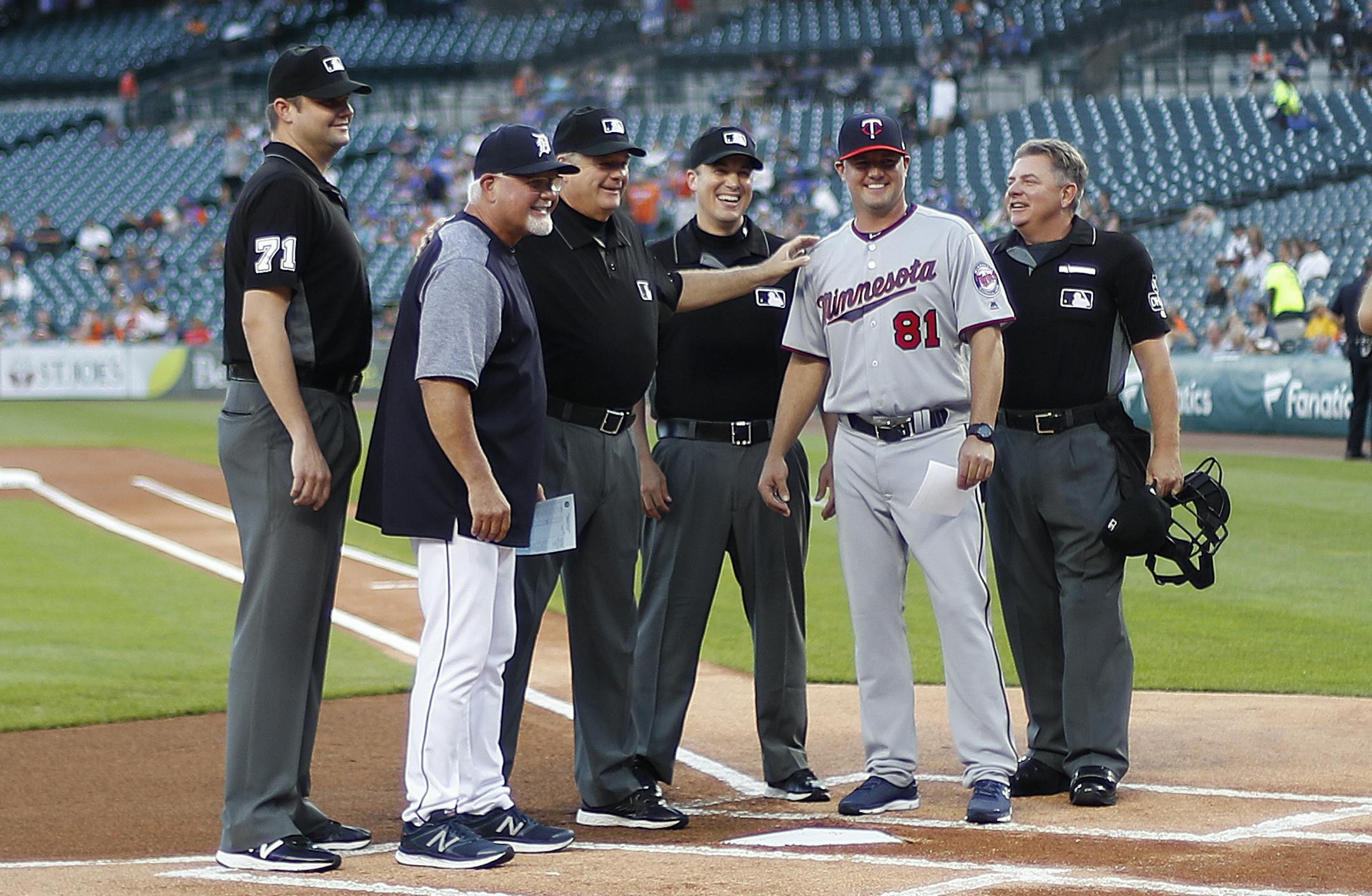 Detroit Tigers manager Ron Gardenhire poses with his son, Minnesota Twins' Toby Gardenhire and umpires, before a baseball game in Detroit, Monday, Sept. 17, 2018. Toby Gardenhire, who managed the Twins Class-A team in Cedar Rapids, is up with the Twins serving and learning under manager Paul Molitor. (AP Photo/Paul Sancya)