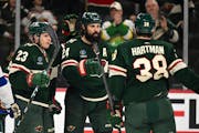 Minnesota Wild center Marco Rossi (23), right wing Ryan Hartman (38) and defenseman Zach Bogosian (24) celebrate a goal by Bogosian against the Tampa 