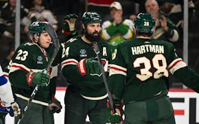 Minnesota Wild center Marco Rossi (23), right wing Ryan Hartman (38) and defenseman Zach Bogosian (24) celebrate a goal by Bogosian against the Tampa