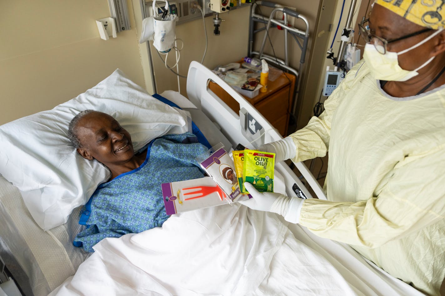 Nurse Tshilanda Nyembwe offers patient Gemma Moturi a selection of personal care products while she receives treatment at Hennepin County Medical Center.