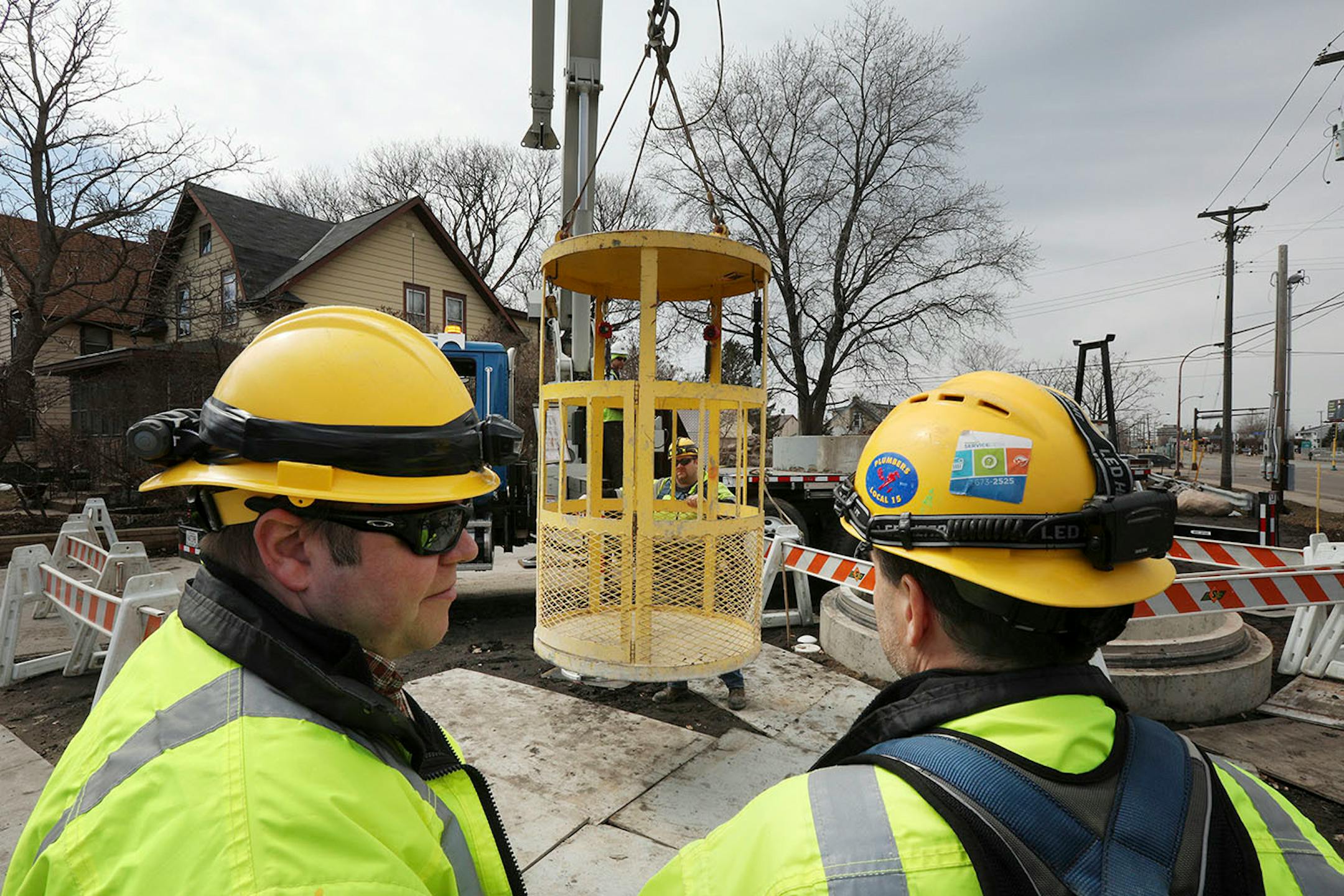 Engineers stood by as a basket for entering Minneapolis' storm sewers was readied for a tour underground.