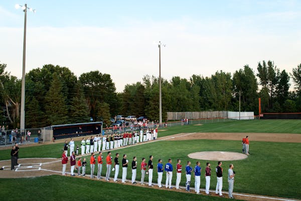 Players from the County Line League, back, and the Stearns County League held their hats over their hearts for the National Anthem before their all-st