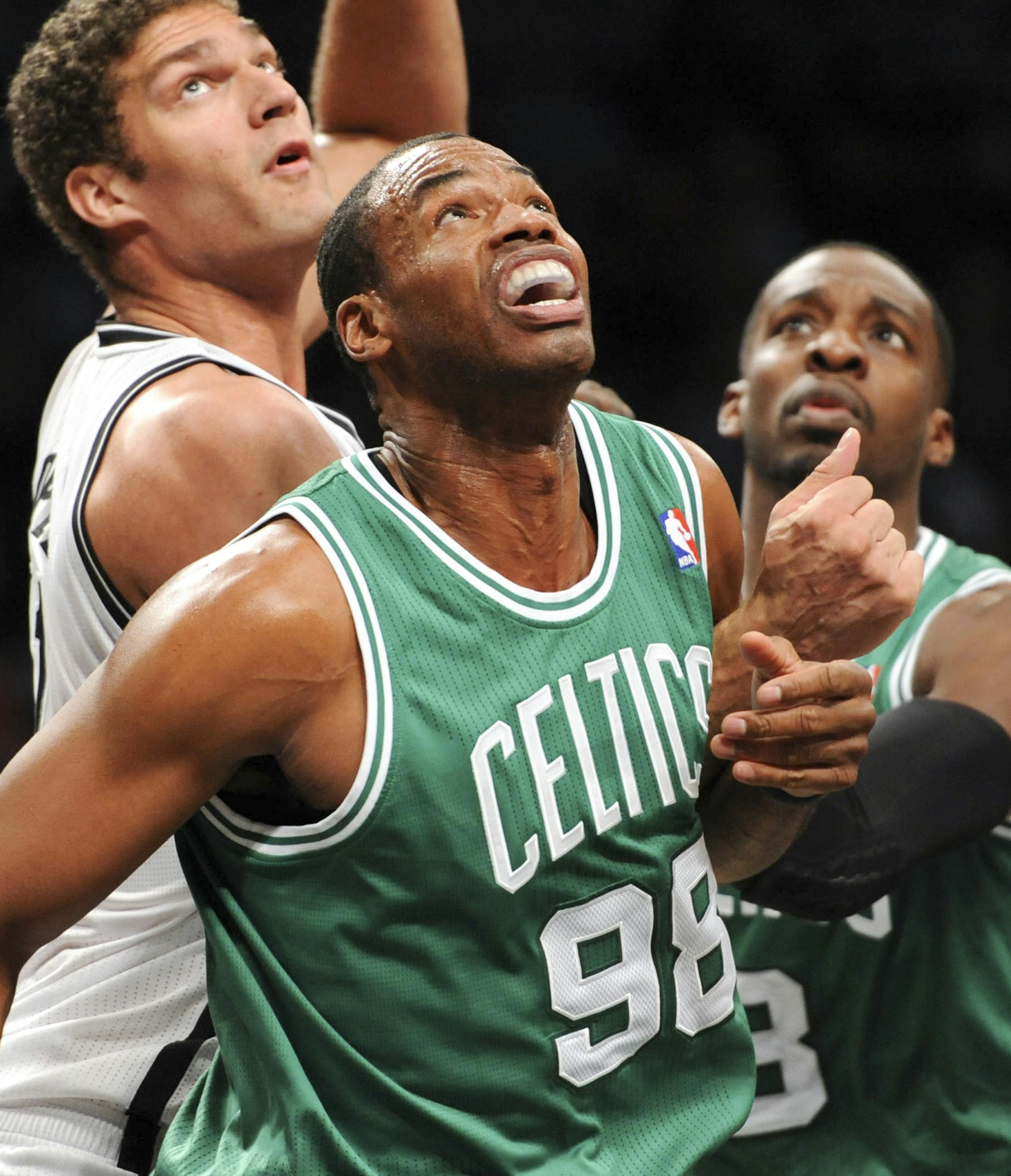 FILE -- Boston Celtics center Jason Collins (98) and Brooklyn Nets center Brook Lopez (11) look for a rebound during an NBA game at Barclays Center in New York, Nov. 15, 2012. Collins, a 12-year N.B.A. veteran who came out on a Sports Illustrated article published online April 29, 2013, is the first openly gay male athlete playing in a major American team sport. (Barton Silverman/The New York Times)
