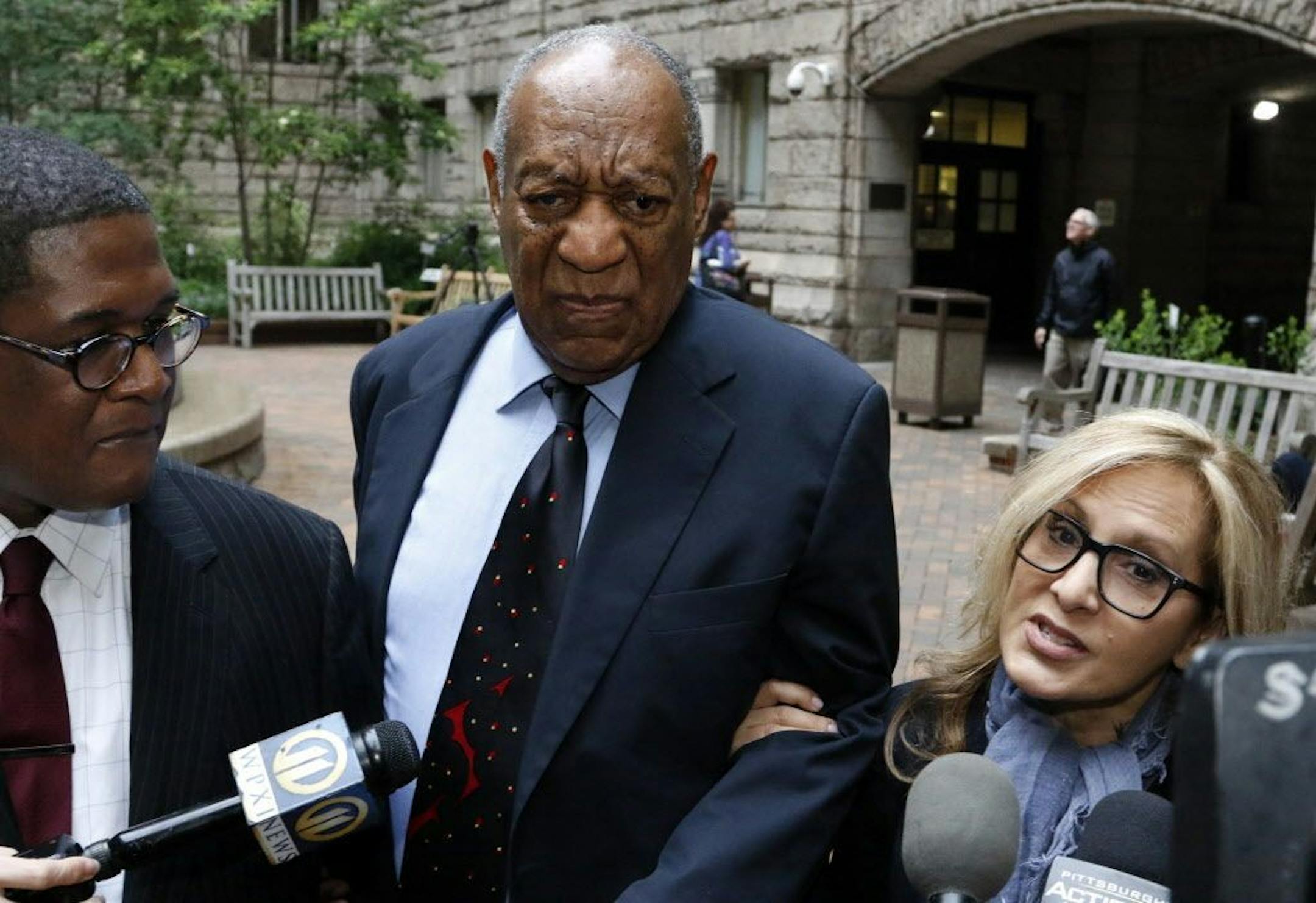 Bill Cosby, center, pauses in the courtyard as one of his attorneys Angela Agrusa, right, makes a statement to the media, as they arrived for the third day of jury selection in his sexual assault case at the Allegheny County Courthouse, Wednesday, May 24, 2017, in Pittsburgh. The case is set for trial June 5 in suburban Philadelphia.