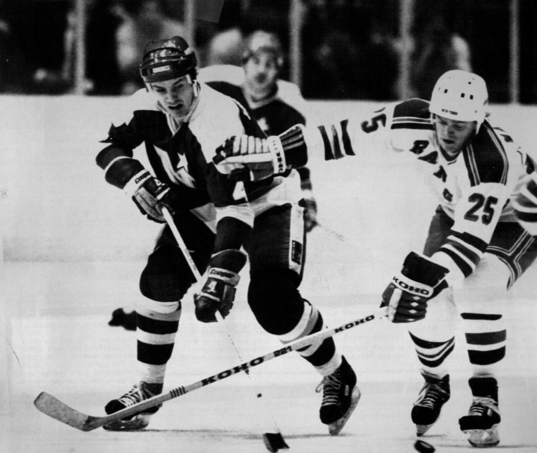 Minnesota North Star defenseman Craig Hartsburg fought New York Ranger Peter Wallin (25) for the puck during a game in January 1982.