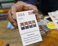 A cashier displays a packet of tobacco-flavored Juul pods at a store in San Francisco.