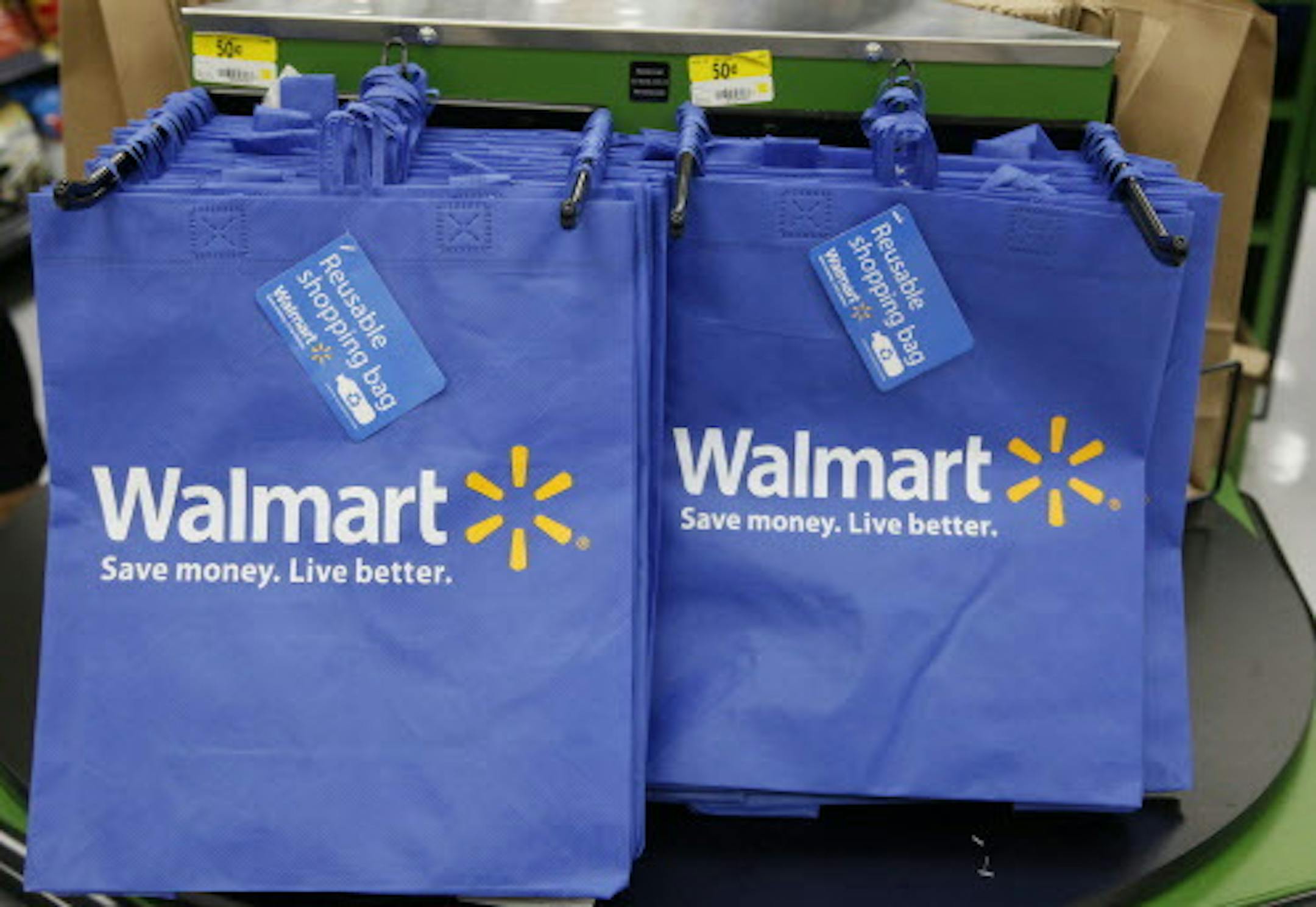 FILE - In this Thursday, Sept. 19, 2013, file photo, reusable shopping bags are offered for sale at a Wal-Mart Neighborhood Market, in the Chinatown district of Los Angeles. Wal-Mart is sharpening its attack against Amazon. The discounter says it is changing its membership-based free shipping service test to two days from three days and is charging one dollar less for the annual membership fee. Wal-Mart began testing the service in 2015 as a way to counter Amazonís highly successful Prime s