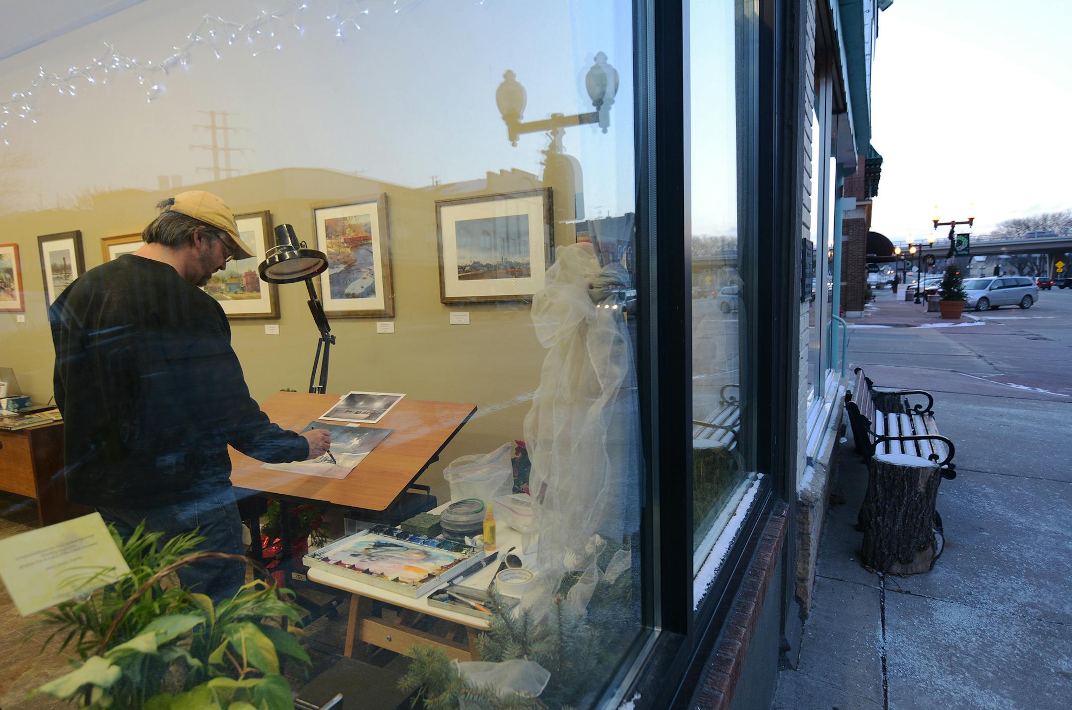 Andy Evansen painted by the window in his new gallery on Second Street in Hastings. Photo by Liz Rolfsmeier, Special to the Star Tribun e