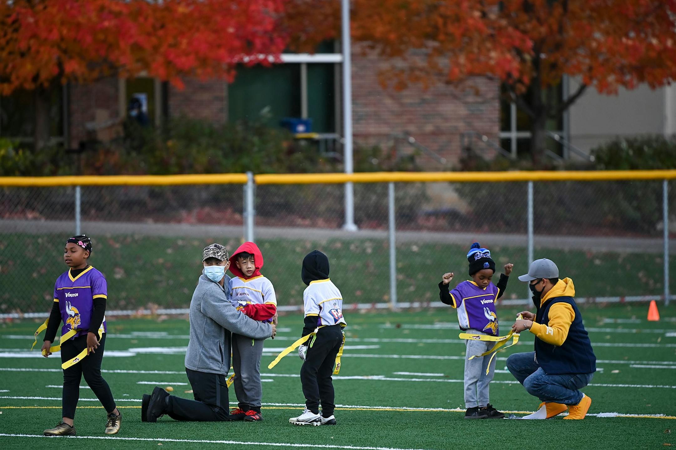 Parents and coaches helped tie flags to their 8U flag football players.