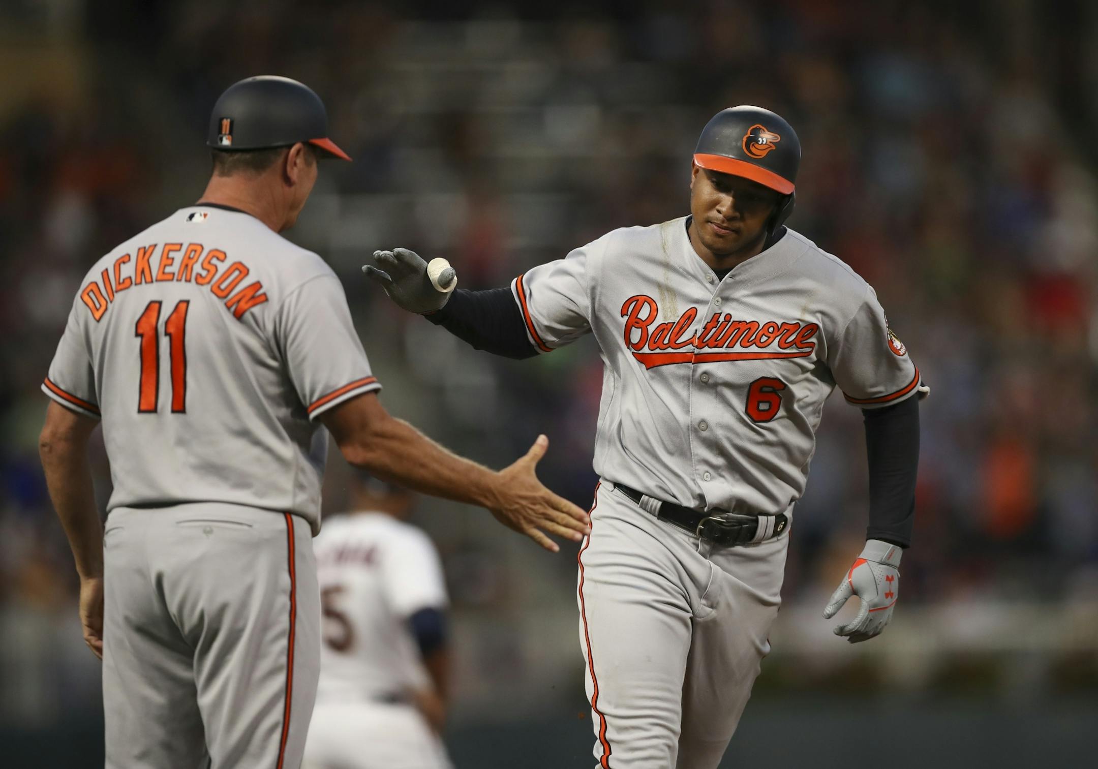 Orioles second baseman Jonathan Schoop prepared to slap hands with Baltimore third base coach Bobby Dickerson after his solo home run in the seventh inning off Twins' reliever Addison Reed.