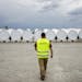 Bloomberg Photo Service 'Best of the Week': A worker walks towards finished turbine blades awaiting transport at the Siemens AG turbine blade plant in