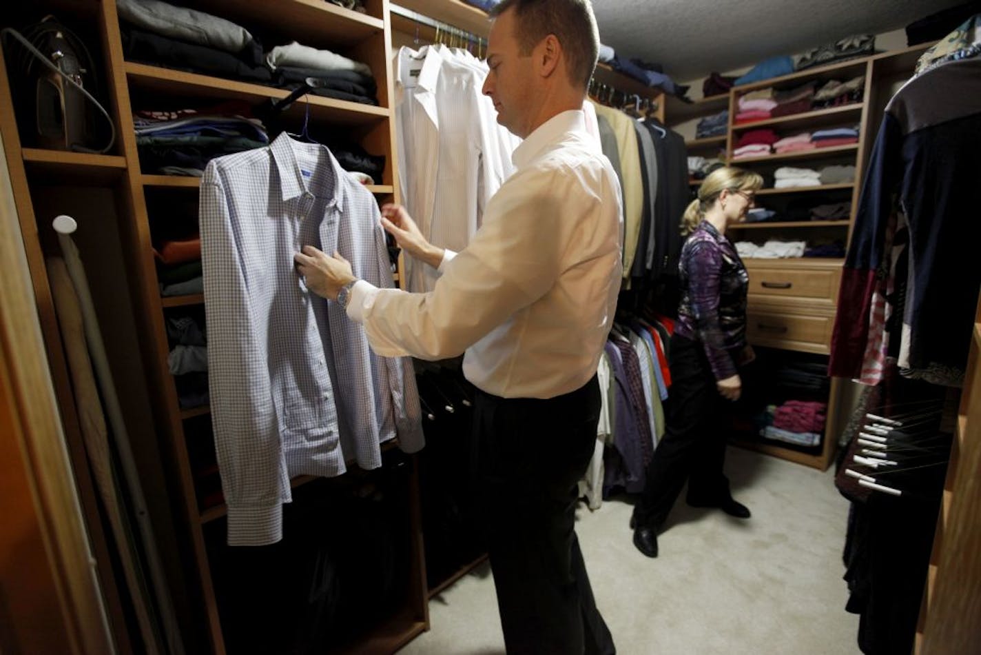 Chris and Tina Arend demonstrate how they use their new closet system at their home in Eagan, Minn. Their closet organization system is from the Closet Factory.