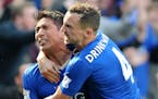 FILE - In this Sunday, April 17, 2016 file photo Leicester City's Leonardo Ulloa celebrates with teammates Leicester City's Danny Drinkwater after sco