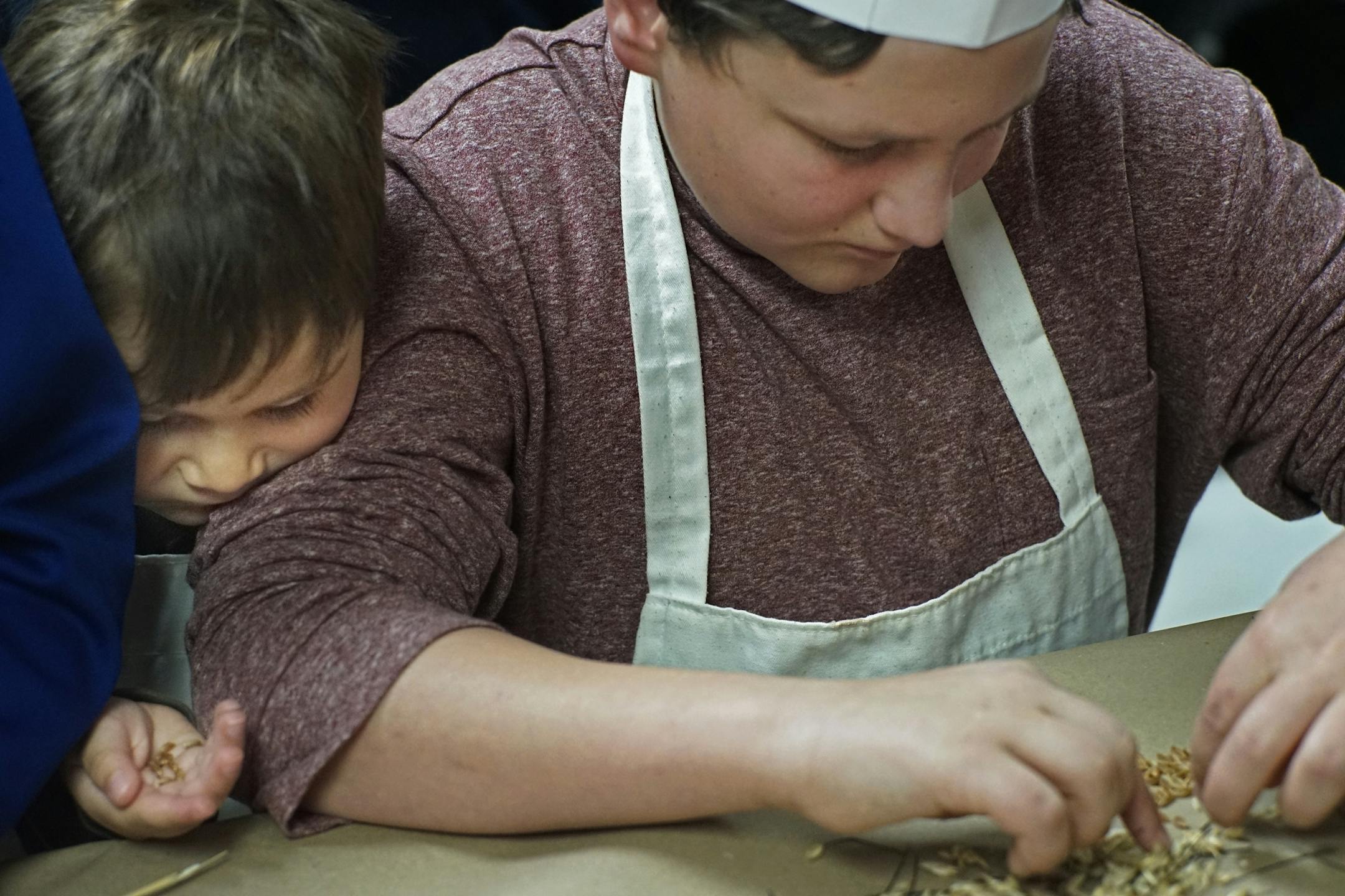 Gabe Kay,4, snuck in there as his brother Sidney separated the wheat seed from the chaff.