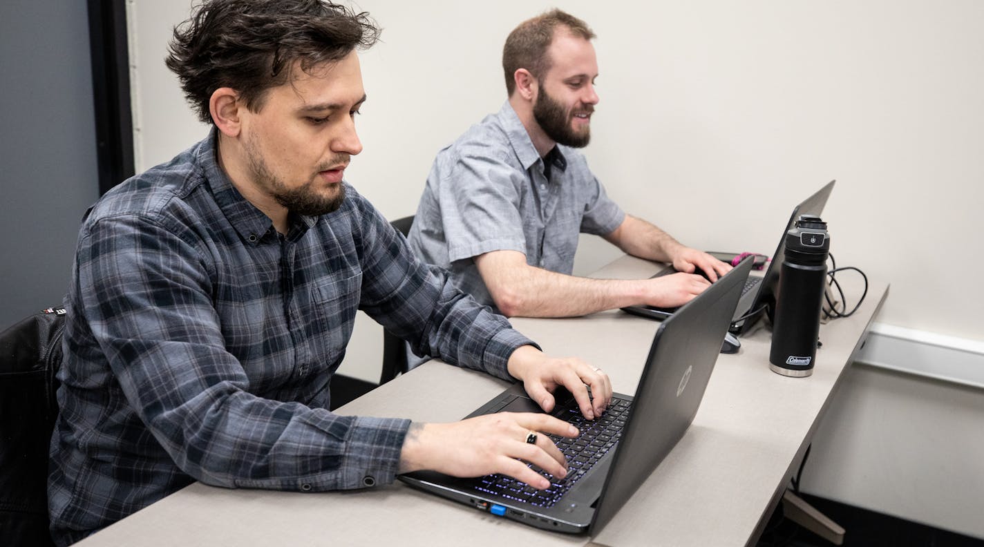 Computer Networking Systems students Jesse Olson, left, and Lucas Burns, right, shown here in their Open Source Software class, are enrolled in Dunwoody College of Technology's Cyber Security program which will begin in the Fall. Photo credit: Kathy M. Helgeson