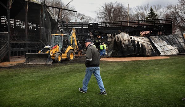 Tink Larson looked over damage at the scene of a fire that swept through a grandstand at historic Tink Larson Field in Waseca.