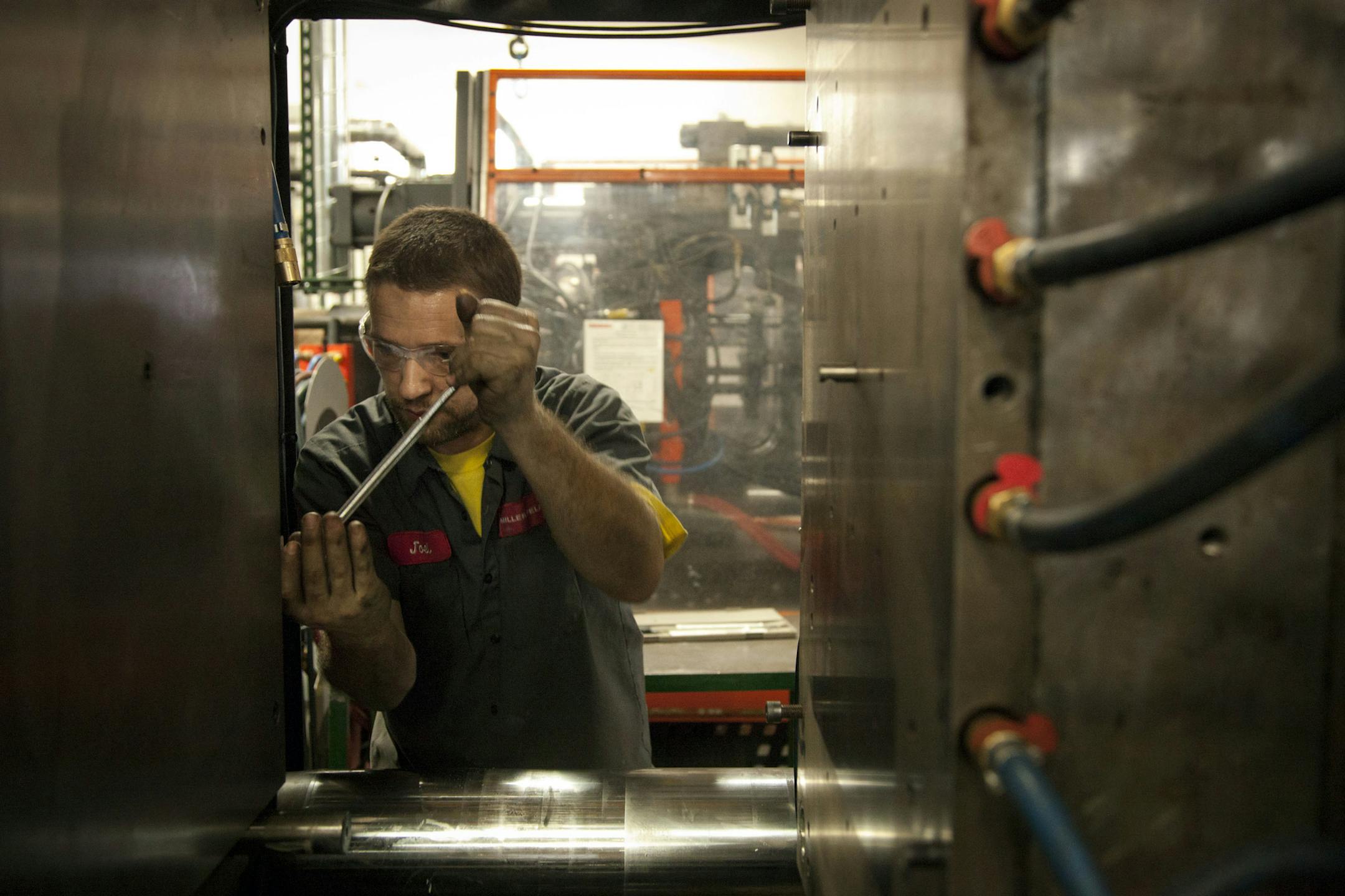Joel Klawiter sets a new mold in an injection molding machine at the Miller Felpax Corp. rail parts manufacturing facility in Winona.